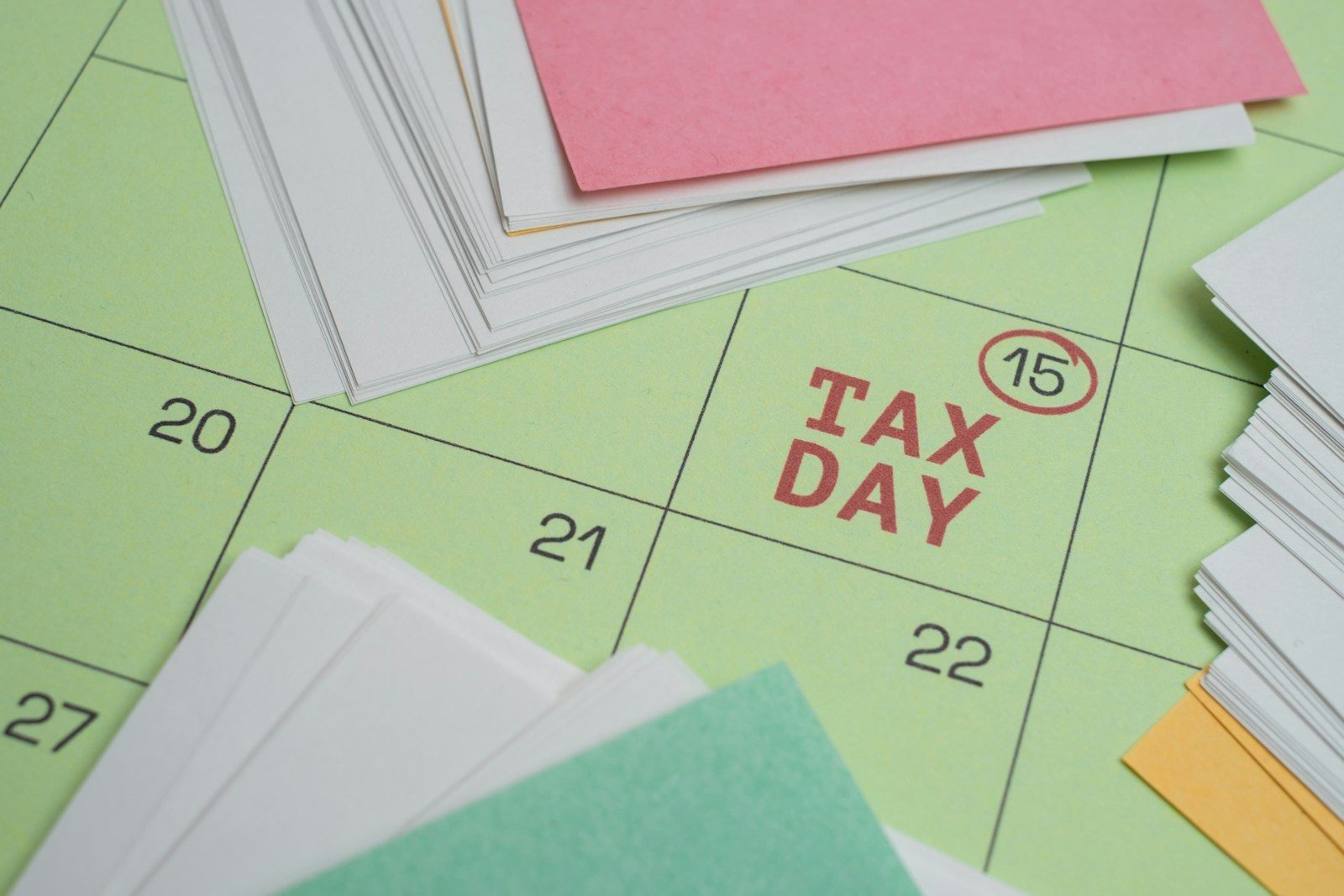 Tax day marked on a calendar with papers.