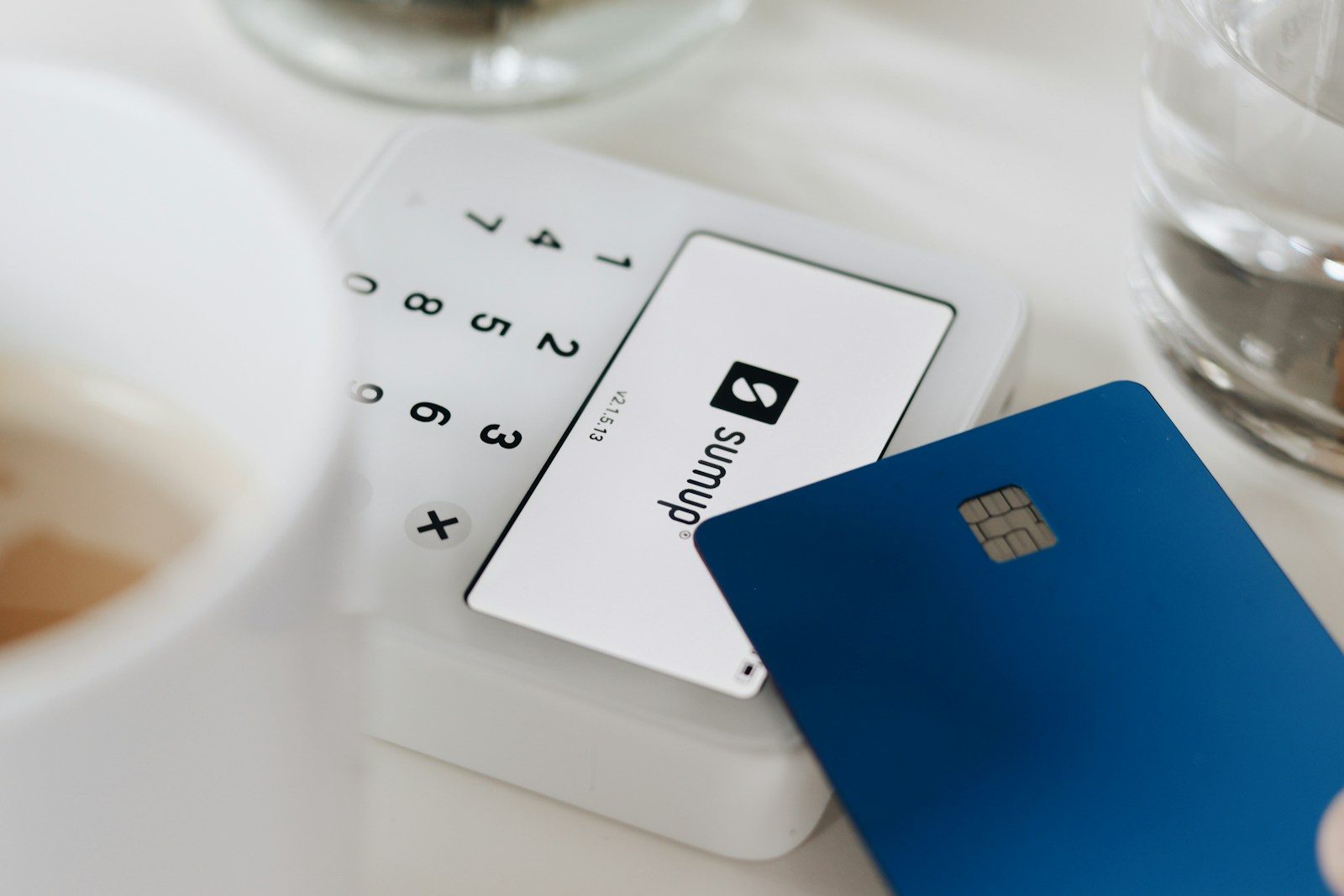 A credit card sitting on top of a table next to a cup of coffee